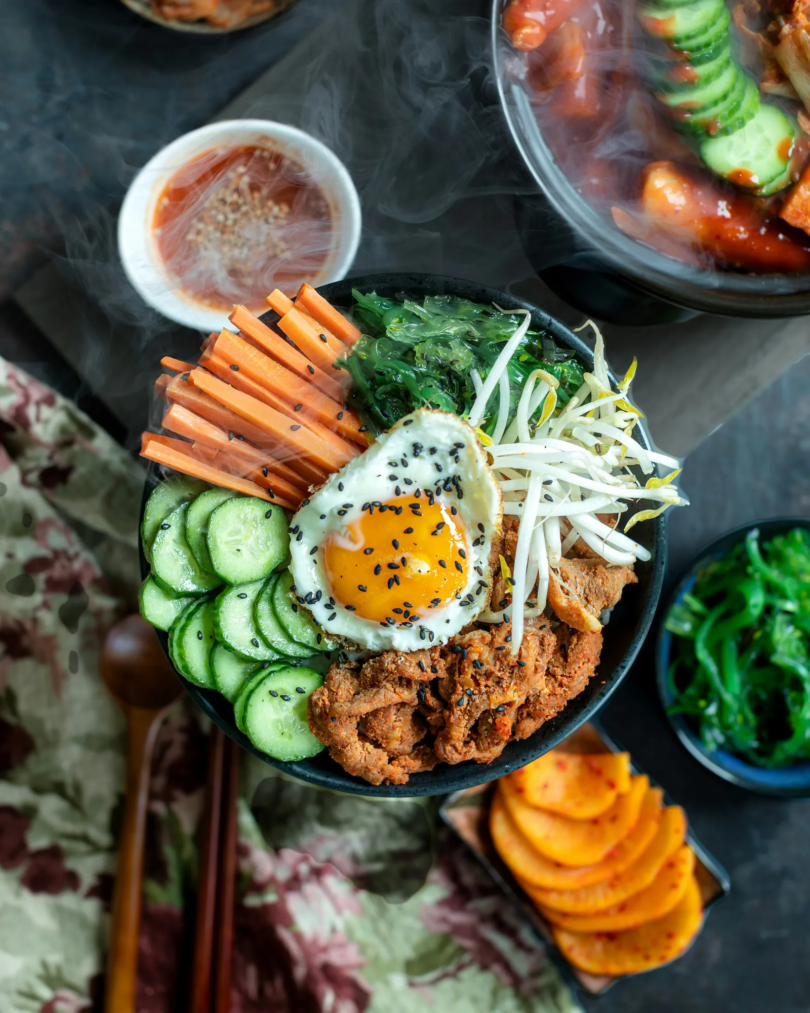 나무판 위 비빔밥과 반찬 그릇을 위에서 본 모습