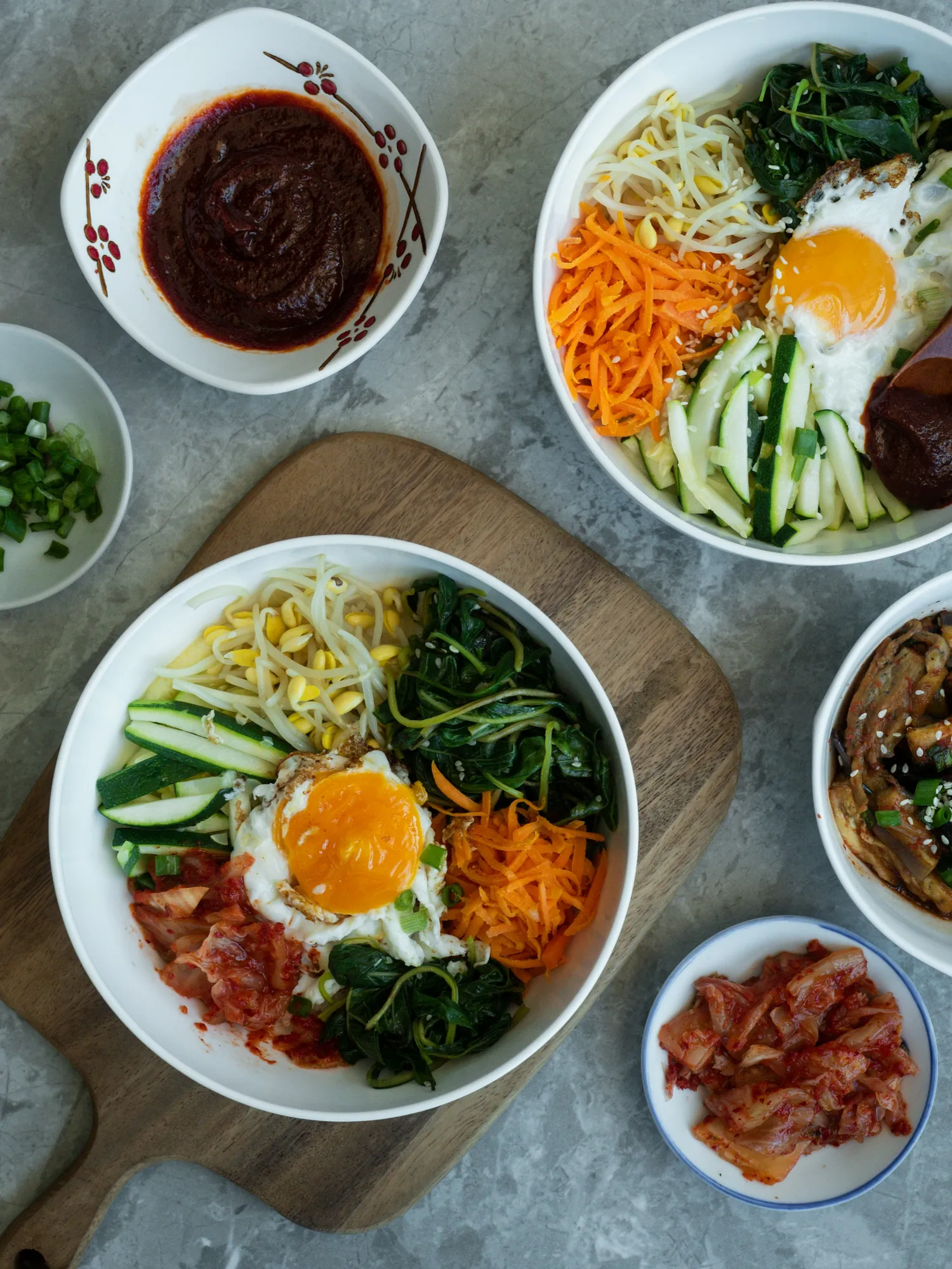흰 그릇 위 비빔밥, 나물과 달걀 고명을 위에서 본 모습